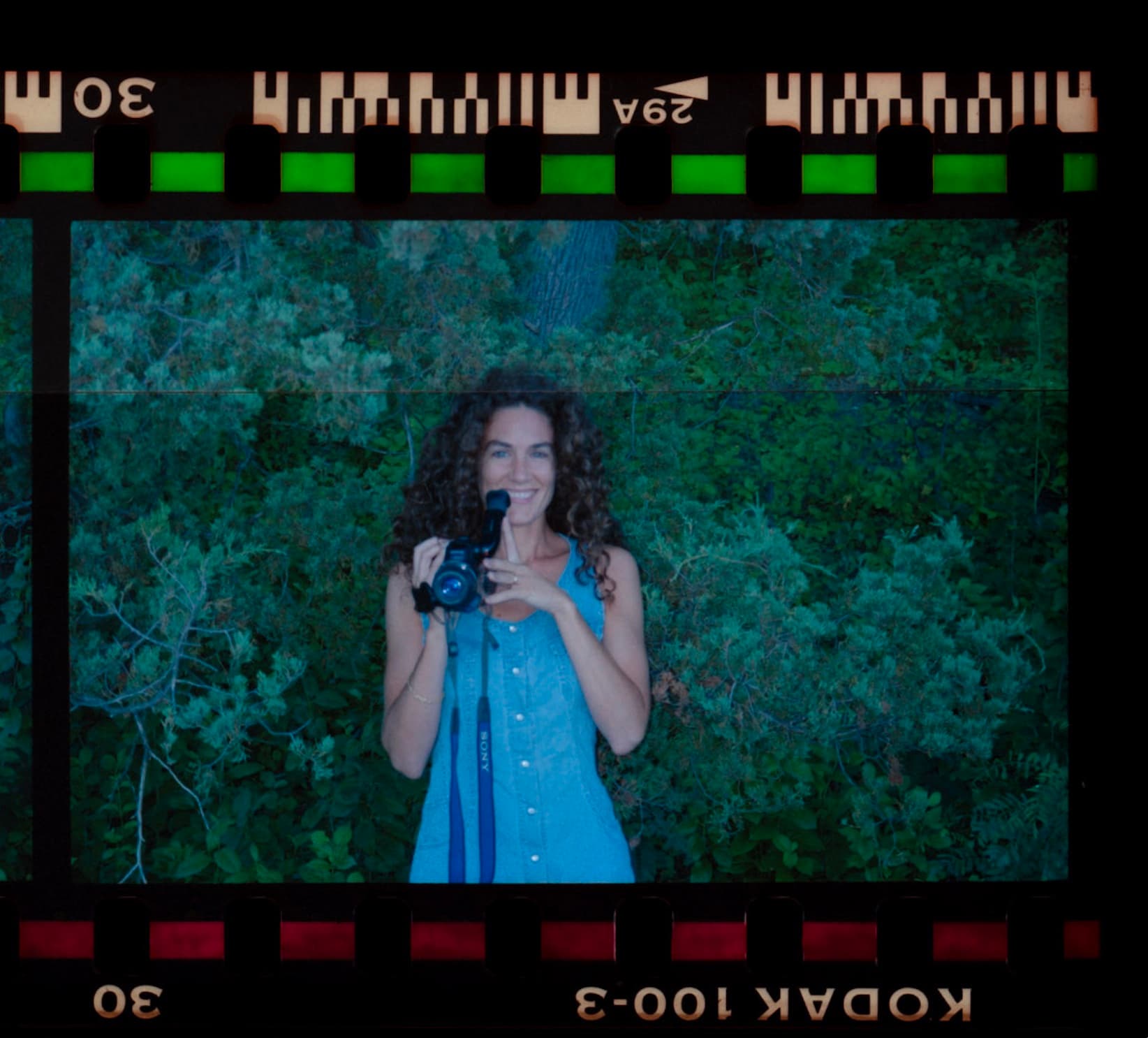 Wendy Claire holding a video camera, framed by a strip of Kodak film