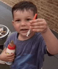 Pâris as a young boy holding up an insulin syringe